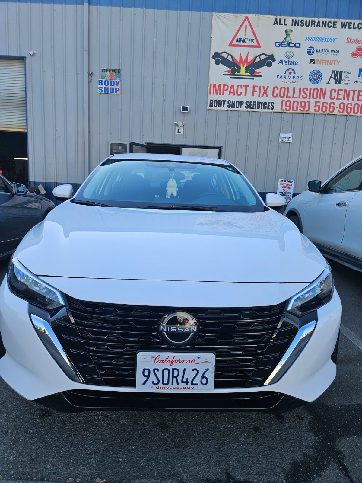 White Nissan front end fully repaired after collision work